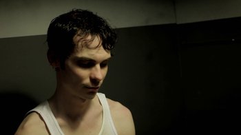 Movie still from “Absentia” (2011), directed by Mike Flanagan – A young man in a white tank top looking down; Close Up shot, Low angle