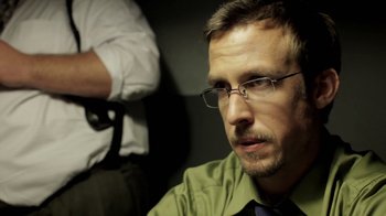 Movie still from “Absentia” (2011), directed by Mike Flanagan – A person wearing glasses and a green shirt; Close Up shot, Low angle