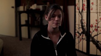 Movie still from “Absentia” (2011), directed by Mike Flanagan – A woman in a black jacket is standing in a room; Close Up shot, Over the shoulder angle