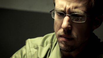 Movie still from “Absentia” (2011), directed by Mike Flanagan – A person wearing glasses and a green shirt; Close Up shot, Low angle