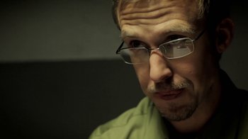 Movie still from “Absentia” (2011), directed by Mike Flanagan – A person wearing glasses and a green shirt; Close Up shot, Over the shoulder angle