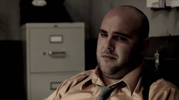 Movie still from “Absentia” (2011), directed by Mike Flanagan – A bald man in a dress shirt and a tie; Close Up shot, Low angle