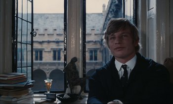 Movie still from “Accident” (1967), directed by Joseph Losey – A man sitting at a table in front of a window; Medium shot, High angle
