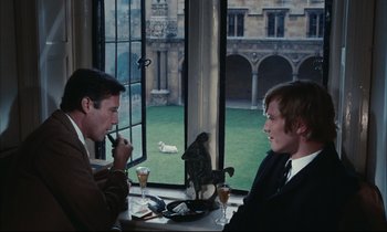 Movie still from “Accident” (1967), directed by Joseph Losey – Two men sitting at a table in front of an open window; Medium shot, High angle