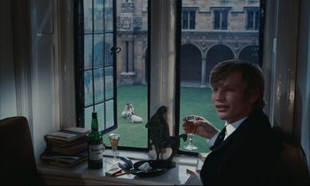 Movie still from “Accident” (1967), directed by Joseph Losey – A man sitting in front of a window holding a wine glass; Medium shot, High angle