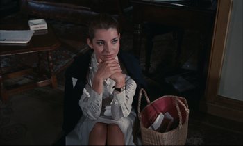 Movie still from “Accident” (1967), directed by Joseph Losey – A woman sitting on the floor with a purse in front of her; Medium shot, High angle