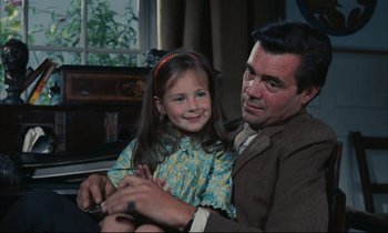 Movie still from “Accident” (1967), directed by Joseph Losey – A man and a little girl sitting on a couch; Medium shot, High angle