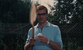 Movie still from “Accident” (1967), directed by Joseph Losey – A man holding a tennis racquet and a ball; Close Up shot, Low angle