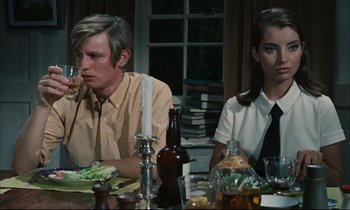 Movie still from “Accident” (1967), directed by Joseph Losey – A man and a woman sitting at a dinner table; Medium shot, High angle