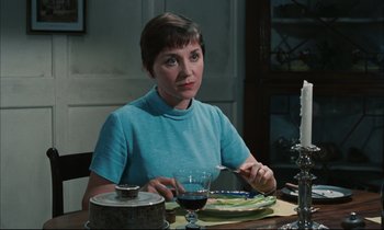 Movie still from “Accident” (1967), directed by Joseph Losey – A woman sitting at a table with a glass of wine; Medium shot, High angle