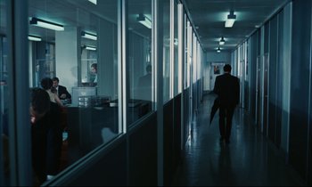 Movie still from “Accident” (1967), directed by Joseph Losey – A man walking down a hallway holding an umbrella; Wide shot, Over the shoulder angle