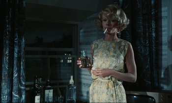 Movie still from “Accident” (1967), directed by Joseph Losey – A woman smoking a cigarette while holding a drink; Medium shot, Low angle