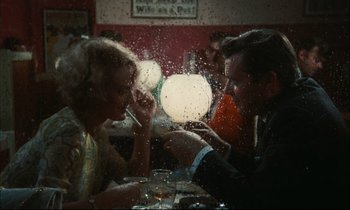 Movie still from “Accident” (1967), directed by Joseph Losey – A man and a woman sitting at a dinner table; Medium shot, Over the shoulder angle