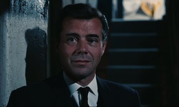 Movie still from “Accident” (1967), directed by Joseph Losey – A person wearing a suit and tie; Close Up shot, Low angle