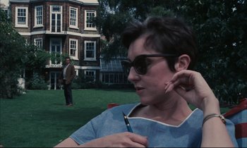 Movie still from “Accident” (1967), directed by Joseph Losey – A woman in a blue shirt is holding a cigarette; Medium shot, Low angle