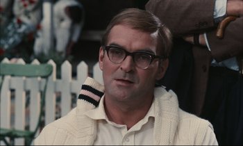 Movie still from “Accident” (1967), directed by Joseph Losey – A person wearing glasses and a sweater; Close Up shot, Over the shoulder angle