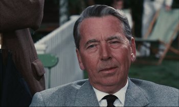 Movie still from “Accident” (1967), directed by Joseph Losey – An older man wearing a suit and tie; Close Up shot, Low angle