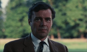 Movie still from “Accident” (1967), directed by Joseph Losey – A person wearing a suit and tie; Close Up shot, Low angle