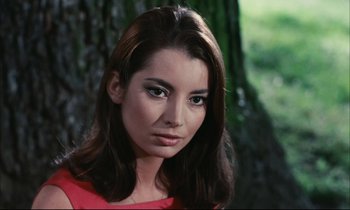 Movie still from “Accident” (1967), directed by Joseph Losey – A beautiful woman in a red shirt in front of a tree; Close Up shot, High angle
