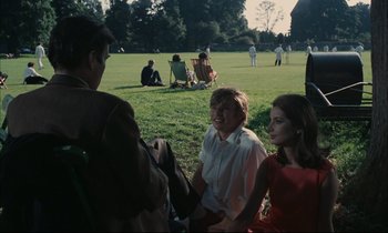 Movie still from “Accident” (1967), directed by Joseph Losey – A group of people sitting in the grass talking; Medium shot, High angle