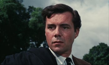 Movie still from “Accident” (1967), directed by Joseph Losey – A person wearing a suit and tie; Close Up shot, Low angle
