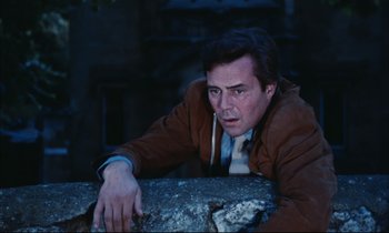 Movie still from “Accident” (1967), directed by Joseph Losey – A man leaning against a wall in the dark; Medium shot, Low angle