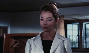 Movie still from “Accident” (1967), directed by Joseph Losey – A woman wearing a white jacket and a black top; Close Up shot, Low angle