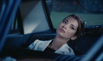 Movie still from “Accident” (1967), directed by Joseph Losey – A woman sitting in the back seat of a car; Close Up shot, Over the shoulder angle