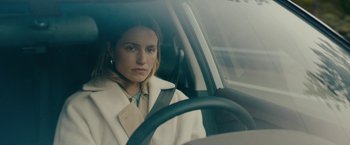 Movie still from “Acidman” (2022), directed by Alex Lehmann – A woman sitting in the driver's seat of a car; Close Up shot, Over the shoulder angle