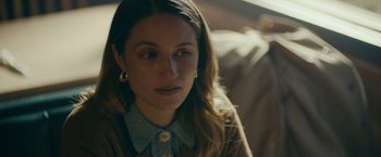 Movie still from “Acidman” (2022), directed by Alex Lehmann – A person sitting on a couch; Close Up shot, Over the shoulder angle