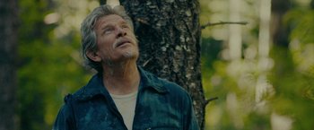 Movie still from “Acidman” (2022), directed by Alex Lehmann – An older man standing next to a tree looking up; Close Up shot, Low angle