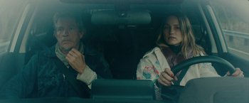 Movie still from “Acidman” (2022), directed by Alex Lehmann – Two people sitting in the back seat of a car; Close Up shot, Over the shoulder angle
