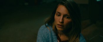 Movie still from “Acidman” (2022), directed by Alex Lehmann – A young woman is sitting in a dark room; Close Up shot, High angle