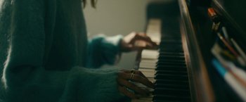 Movie still from “Acidman” (2022), directed by Alex Lehmann – A person is playing the piano with a ring on their finger; Extreme Close Up shot, High angle