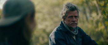 Movie still from “Acidman” (2022), directed by Alex Lehmann – An older man with a beard and a scarf; Close Up shot, Over the shoulder angle