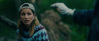 Movie still from “Acidman” (2022), directed by Alex Lehmann – A woman wearing a hat and a sweater looks at the camera; Close Up shot, Over the shoulder angle