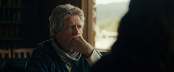 Movie still from “Acidman” (2022), directed by Alex Lehmann – An older man sitting in front of a window; Close Up shot, Over the shoulder angle