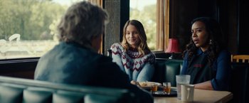Movie still from “Acidman” (2022), directed by Alex Lehmann – A woman sitting at a table in front of a man; Medium shot, Over the shoulder angle