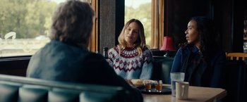 Movie still from “Acidman” (2022), directed by Alex Lehmann – A woman sitting at a table in front of a man; Medium shot, Over the shoulder angle