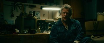 Movie still from “Acidman” (2022), directed by Alex Lehmann – A man sitting in front of an old television set; Close Up shot, Low angle