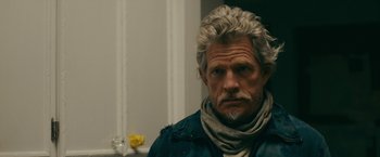 Movie still from “Acidman” (2022), directed by Alex Lehmann – A person wearing a scarf; Close Up shot, Over the shoulder angle