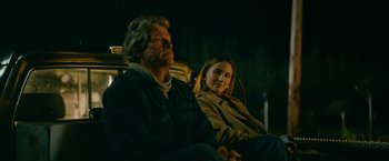 Movie still from “Acidman” (2022), directed by Alex Lehmann – A man and a woman sitting next to each other; Medium shot, Low angle