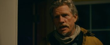 Movie still from “Acidman” (2022), directed by Alex Lehmann – An older man with a gray beard is looking at the camera; Close Up shot, Over the shoulder angle