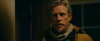 Movie still from “Acidman” (2022), directed by Alex Lehmann – An older man wearing a scarf and a jacket; Close Up shot, Over the shoulder angle