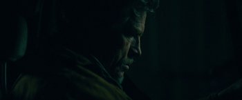 Movie still from “Acidman” (2022), directed by Alex Lehmann – A person in a dark room; Close Up shot, Low angle