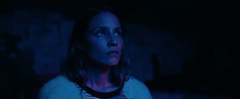 Movie still from “Acidman” (2022), directed by Alex Lehmann – A woman is looking up at the sky at night; Close Up shot, Low angle