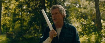Movie still from “Acidman” (2022), directed by Alex Lehmann – An older man holding a white plastic tube in his hand; Medium shot, Over the shoulder angle