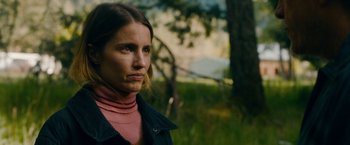 Movie still from “Acidman” (2022), directed by Alex Lehmann – A person wearing a jacket near a tree; Close Up shot, Low angle