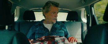 Movie still from “Acidman” (2022), directed by Alex Lehmann – An older man sitting in the back of a car; Medium shot, High angle