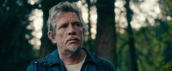 Movie still from “Acidman” (2022), directed by Alex Lehmann – An older man with grey hair and a white beard; Close Up shot, Low angle